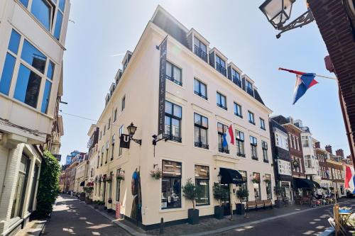 a building on a street with flags on it at ARQ Paleis Hotel in The Hague