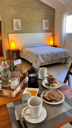 a table with plates of food and a bed in a room at La Serena Suites Apart hotel in La Paloma