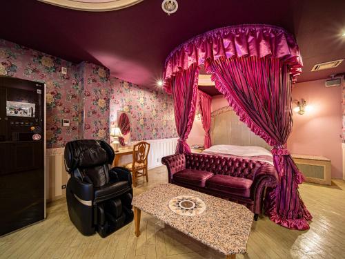a bedroom with a canopy bed and a chair at Hotel LaLa (Adult Only) in Sakai