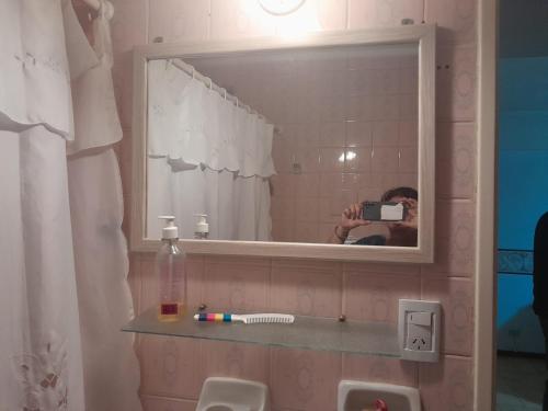a person taking a picture of a mirror in a bathroom at Atlántico Peatonal in Necochea