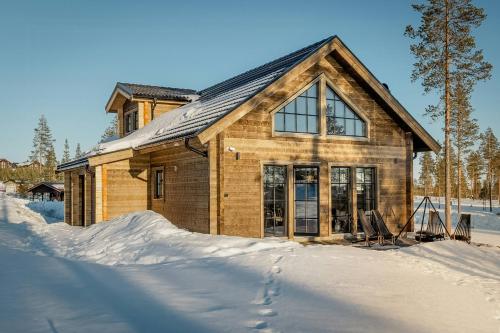una casa de madera en la nieve delante en Modern Cabin With Ski In Ski Out In Idre Himmelfjäll, en Idrefjäll