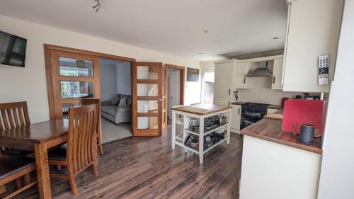 a kitchen and living room with a table and a dining room at Sydenham Serenity: Bright Home with Conservatory in Belfast