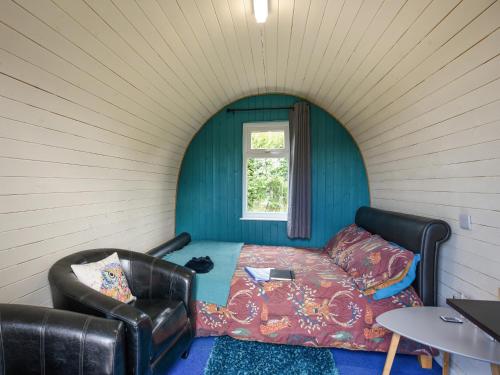 a room with a bed and a chair and a window at The Owl Pod - Uk50070 in Welshpool