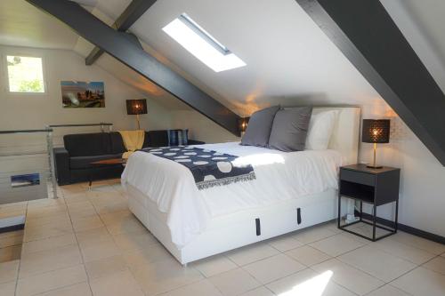 une chambre avec un lit et un canapé dans un grenier dans l'établissement Le Bella Vista, vue panoramique lac & montagne, à Saint-Jorioz