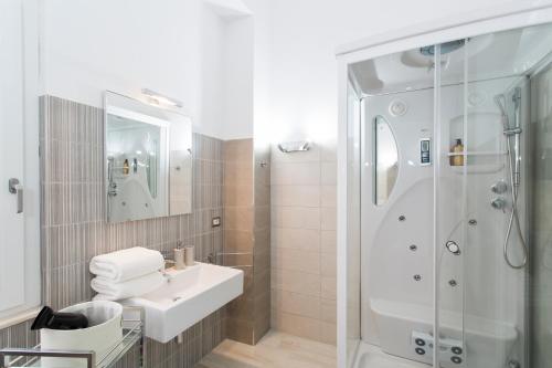 a white bathroom with a shower and a sink at Casa Piazzé IUN Q0873 in Bosa