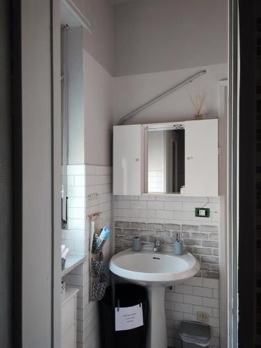 a white bathroom with a sink and a mirror at L'angolo in Biella