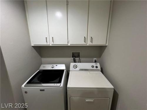 a small kitchen with a stove and white cabinets at T-Designed to ENJOY!. Best Vacation in Las Vegas