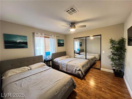 a bedroom with two beds and a mirror at T-Designed to ENJOY!. Best Vacation in Las Vegas