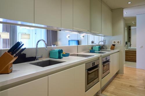 a kitchen with white cabinets and a sink at Serviced Apartments Boavista Palace in Porto