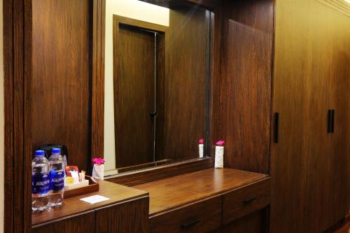 een badkamer met een grote spiegel en een houten kast bij Hotel Meridien in Gujrānwāla