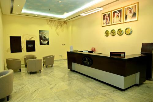 a lobby with a reception desk and chairs at Aspire Tower in Manama