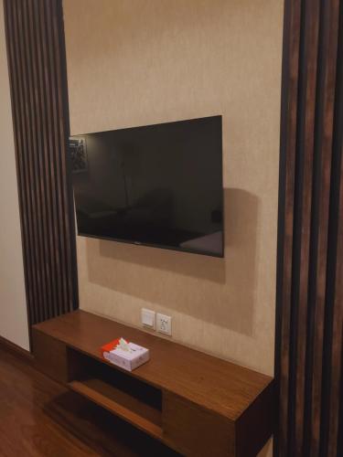 een woonkamer met een tv aan de muur bij Hotel Meridien in Gujrānwāla