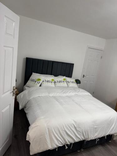 a bedroom with a large bed with white sheets and pillows at Whitford living 1 South Shields in West Boldon