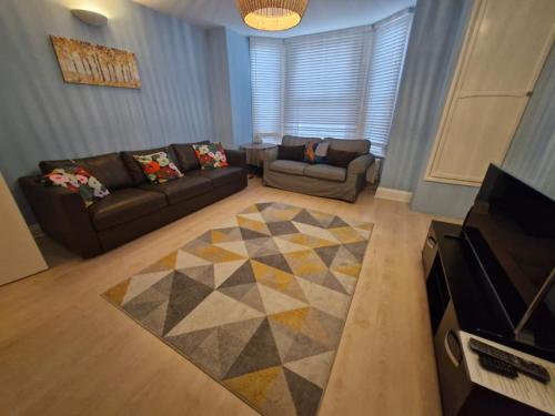 a living room with two couches and a rug at Charming Retreat - Broadstairs Seafront in Broadstairs