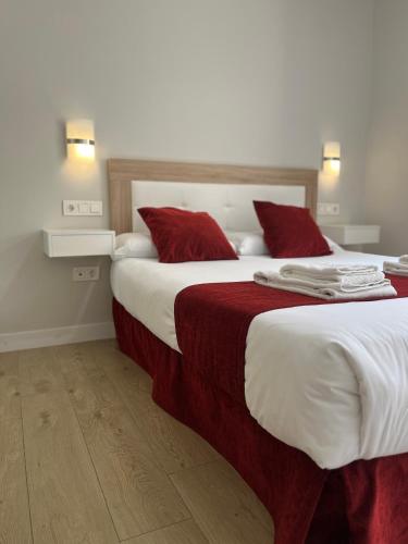 a bedroom with a large bed with red pillows at Pinar Málaga Centro, Rooms in Málaga
