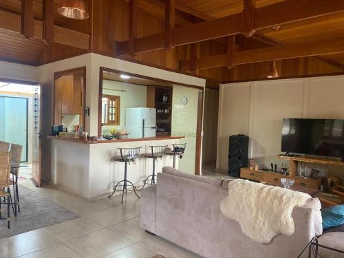 Una sala de estar con un sofá y una cocina. en Refúgios SUNSET Serra Fluminense, en Areal