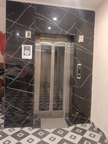 a bathroom with a walk in shower with black marble walls at hotel la casa in Jāmb