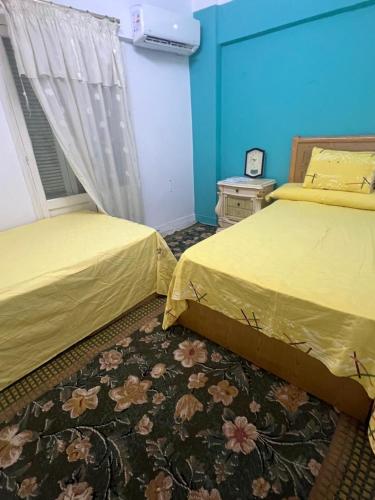 een slaapkamer met 2 bedden en een tapijt bij Roma apartment in Dumyat al Jadidah