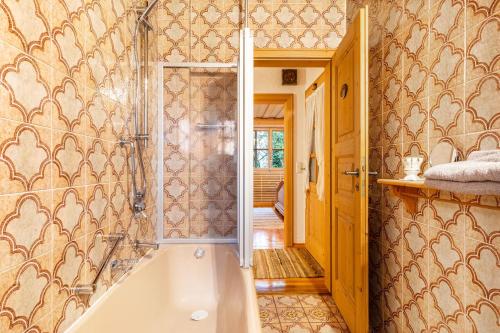 een badkamer met een bad en een inloopdouche bij Vroni Ferienwohnung - Hochzoll in Friedberg