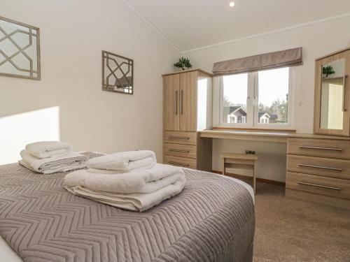 a bedroom with two white towels on a bed at Bluebell Lodge in Carnforth
