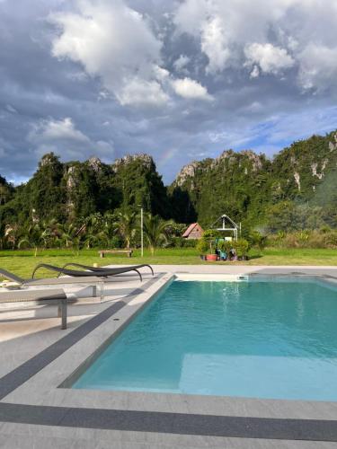 a swimming pool with mountains in the background at วันทน่า พูลวิลล่า เนินมะปราง in Ban Mung