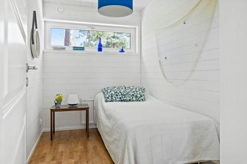 a small bedroom with a bed and a window at Modern Archipelago Cabin With Hot Tub On Timrarön in Vadholma