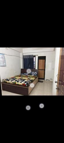 a bedroom with a bed in a room at Gurukrupa Home stay in Rājpīpla