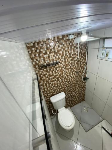 Casa acomoda 2 casal في غواراتينغيتا: حمام به مرحاض وجدار بلاط