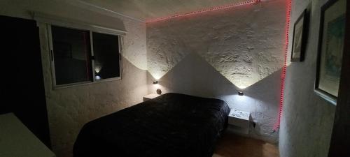 a room with a bed and two lights on the wall at Kasty in Piriápolis