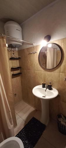 a bathroom with a sink and a mirror and a toilet at Kasty in Piriápolis