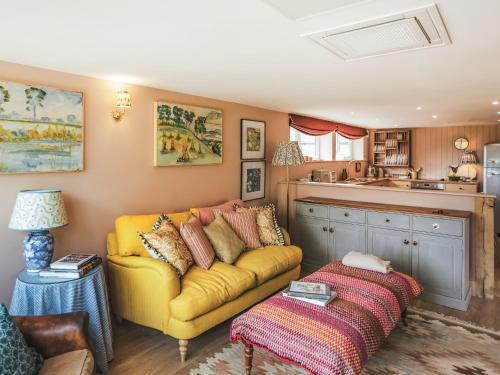 a living room with a yellow couch and a table at The Shearing Shed in Peasmarsh