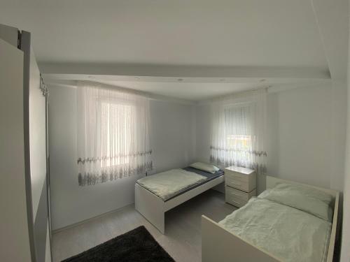 een slaapkamer met twee bedden en twee ramen bij WgCetin in Göppingen