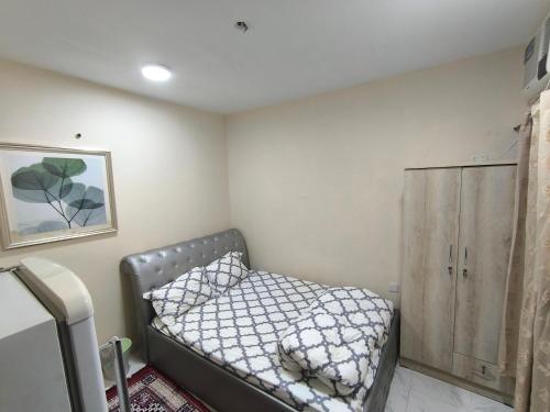 a small bedroom with a bed and a cabinet at Rooms for family near to bus station in Ajman