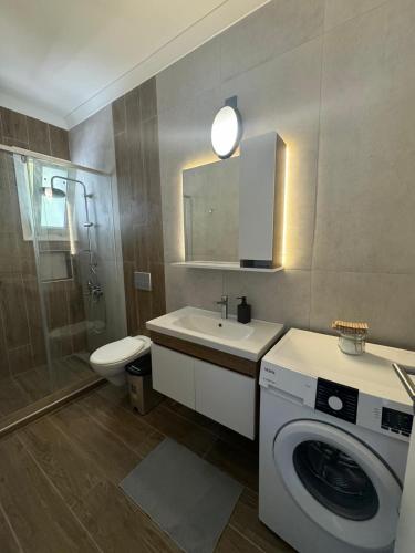 a bathroom with a washing machine and a sink at Kıbrıs Girnede 1 yatak odalı Süper lüks havuzlu daire in Vuda