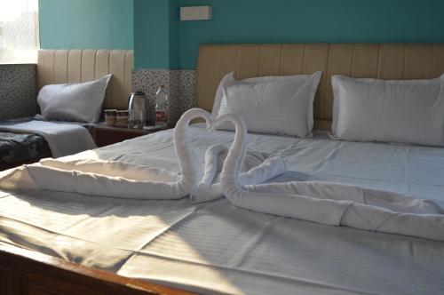 a bed with two swans made out of towels at Aakarsh Hill View Hotel in Rājgīr