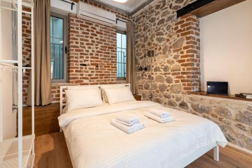 a bed in a room with a brick wall at Stone studio just a 3min walk from the Clock Tower in Konak