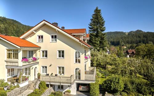 a large white house with balconies and trees at Ferienwohnungen Haus Irene in Bodenmais