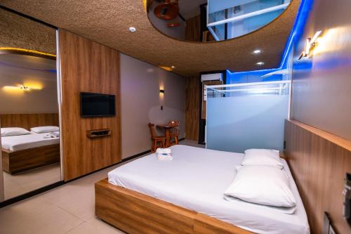una stanza d'albergo con un letto e uno specchio di Jardins Motel (Adults Only) a Maceió