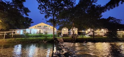 un edificio con luci di fronte a un fiume di notte di ไวท์ เฮ้าท์ แคมป์ ชะอม a Ban Bung Mai