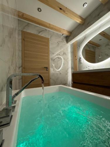 a bathroom with a tub with a water fountain at Villa Segny Chalet in Ségny
