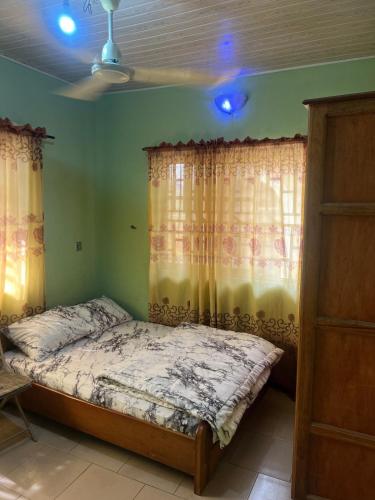 een slaapkamer met een bed in een kamer met gordijnen bij Otam Homes in Ondo