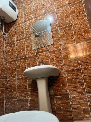 een badkamer met een wastafel en een bakstenen muur bij Otam Homes in Ondo