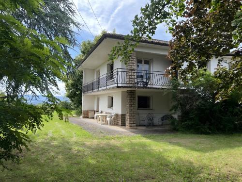 a white house with a balcony and a yard at Adélaide Cottage in Chevagny-les-Chevrières