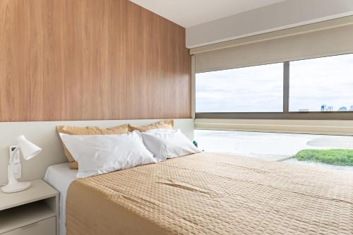a bedroom with a bed and a large window at Vista Incrível para o Rio e Mar - PC907 in Recife