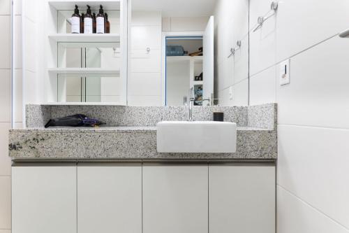 a white bathroom with a sink and a mirror at Vista Incrível para o Rio e Mar - PC907 in Recife