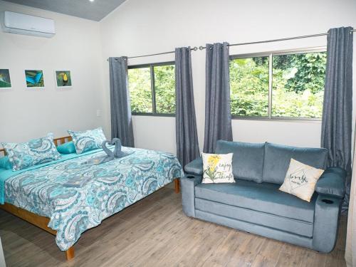 a bedroom with a bed and a couch and a window at Luxury Apartments Nauyaca by Paradiselodge in Platanillo
