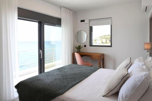 een slaapkamer met een bed en een groot raam bij Rozites Luxury Beachfront Villa, By Hellocrete in Kerames