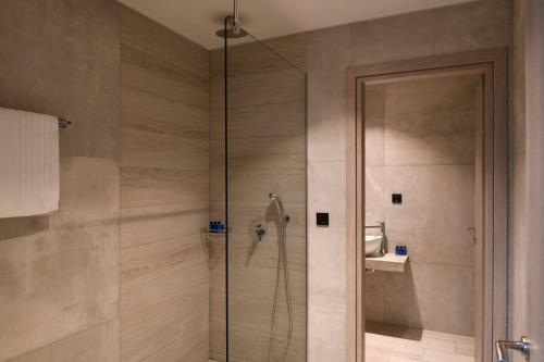 een douche met een glazen deur in een badkamer bij Rozites Luxury Beachfront Villa, By Hellocrete in Kerames