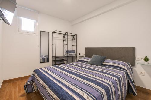 une chambre avec un grand lit et une couverture à rayures dans l'établissement El Hierro, à La Victoria de Acentejo