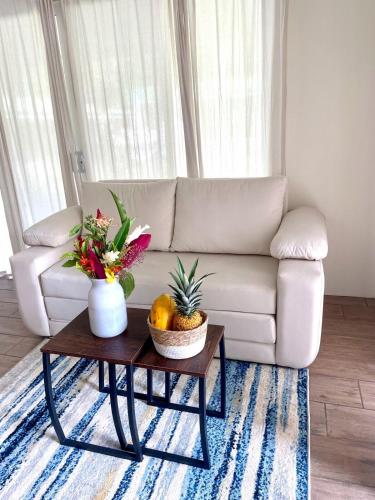a living room with a couch and a table with flowers at Casa Linda in Platanillo